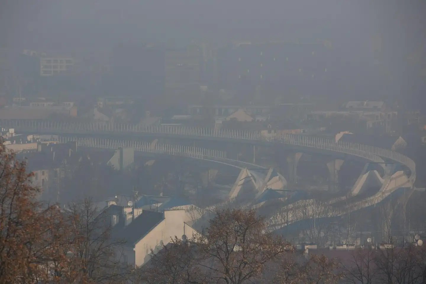 Kraków w smogu: estakada i dachy kamienic giną w gęstej, szarej mgle